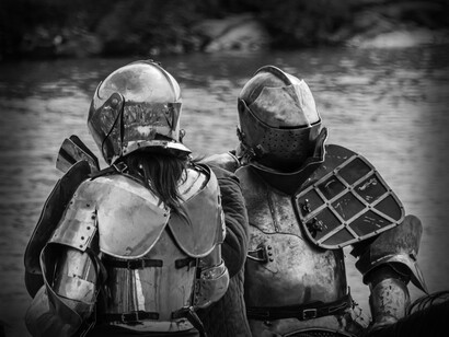 Two medival knights discuss their plans on the river