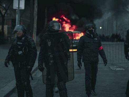 Police officers stand watchful during protests in Paris, France, as demonstrators voice their anger over recent political shifts and the dissolution of the National Assembly