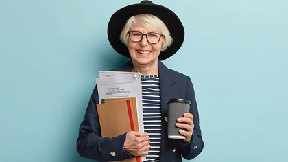 Senior woman holding documents and coffee