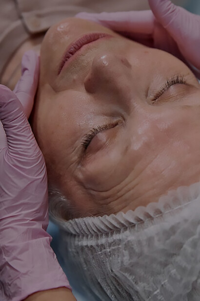 Eternal glow: experience as a senior woman undergoes skilled filler application by a doctor in pink gloves, bringing about timeless facial enhancement