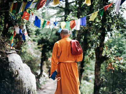 Amidst the thin mountain air, a monk's meditative walk through Gokyo reflects a deep connection to both nature and spiritual reflection, navigating the heights with grace