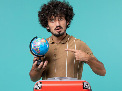 Man relocating abroad with a small globe in hand, representing his upcoming international adventure
