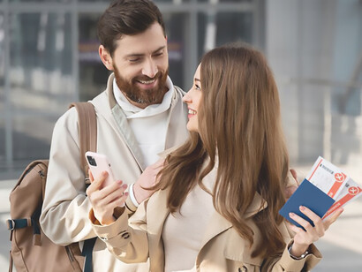 Symbolizing the impact of brain drain, a smiling couple proudly displays their passports, reflecting the international migration of skilled workers seeking new opportunities