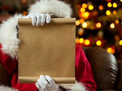 A cheerful Santa Claus stands beside a beautifully decorated Christmas tree, thoughtfully reading a long roll of paper filled with holiday wishes