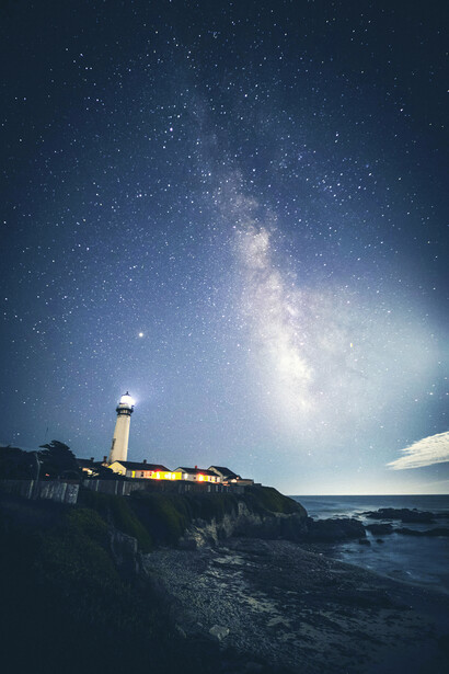 A lighthouse stands alone in the night