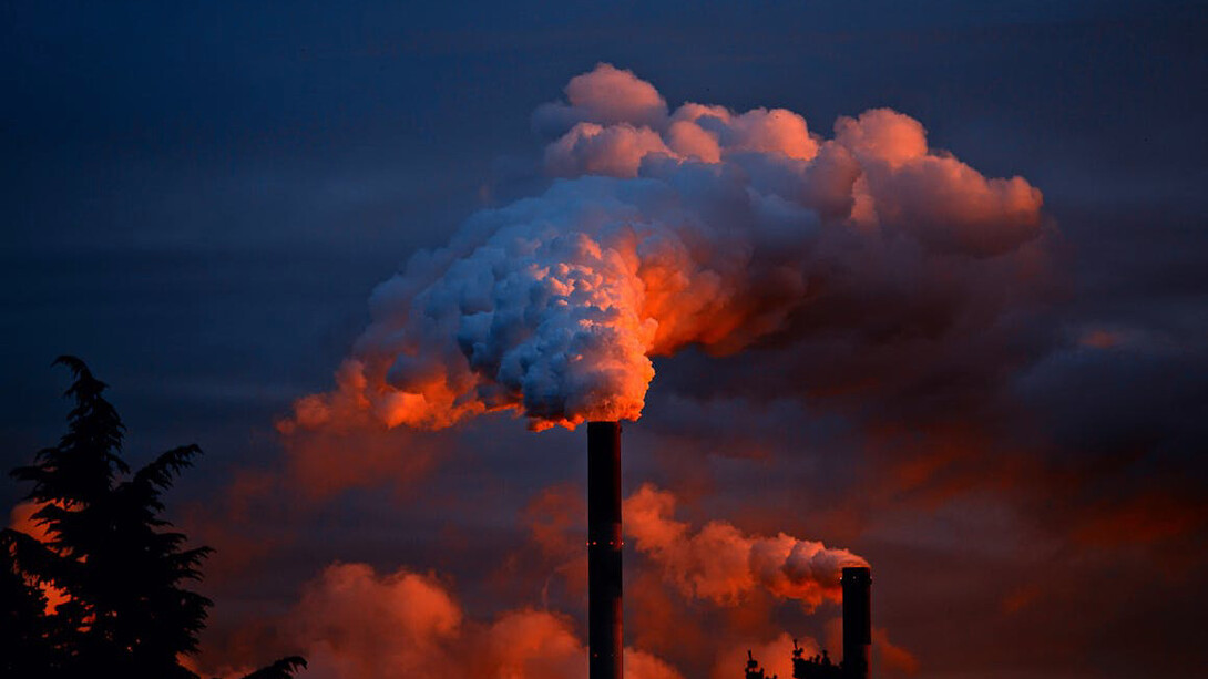 This stark image of factories emitting thick plumes of smoke illustrates the environmental challenges posed by industrialisation, highlighting the urgent need for sustainable practices