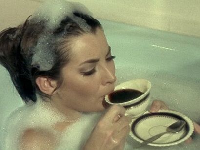 A woman drinking coffe in a bathtub