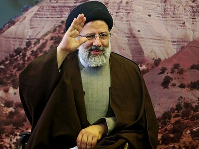 Iran's former president Ebrahim Raisi waving at a press confernce
