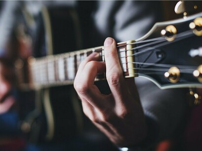 Dettaglio di diteggiatura mentre viene suonata una chitarra. Lo studio e la pratica sono fondamentali nel suonare uno strumento