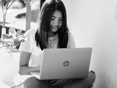 A girl working on her homework on a laptop online
