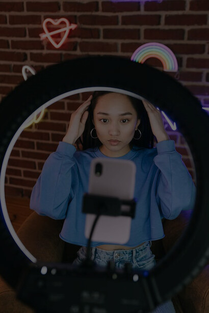 An influencer using her phone and lighting equipment to record herself