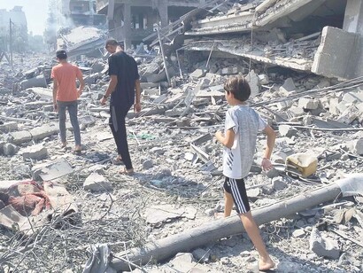 Palestinians survey the devastation of Aklouk Tower, destroyed by Israeli airstrikes in Gaza City on October 8, 2023