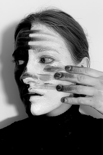 The woman's face is divided into halves, with one side black and the other side white, symbolizing the inner disconnection she embodies