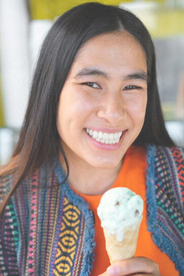 Central American woman savoring a delicious ice cream treat, capturing a moment of joy and relaxation in vibrant regional style