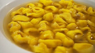 Piatto di tortellini in brodo, tipico della tradizione culinaria bolognese