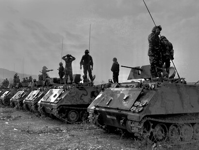 Lined up military tanks and soldiers. Our world collectively pours some 1.5 trillion US dollars down the toilet of militarism annually