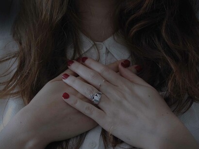 A woman's hands are on her chest as a symbol of gratitude for all that she has received and will continue to envisage