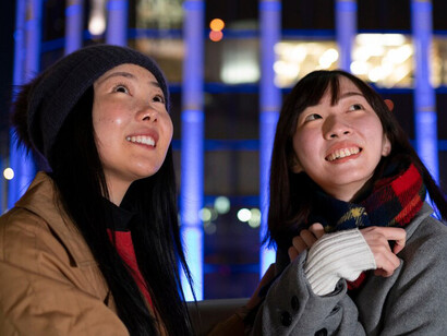 Two smiling friends enjoys their time together, hanging out in the vibrant city of South Korea