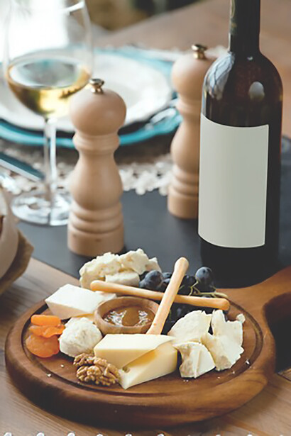 The delightful presentation of a cheese plate paired with a glass of red wine, showcasing Pecorino Romano cheese and flavorful Guanciale in a captivating front view shot