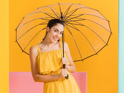 Woman in a yellow dress holding an umbrella, set against a vibrant, colorful background