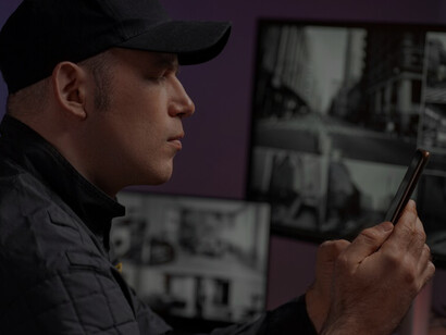 Portrait of a male security guard monitoring radio station and camera screens