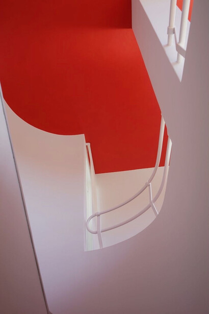 The dynamic red ceiling contrasts vividly with the smooth, white walls of the staircase, highlighting Vilamajó’s unique approach to colour and spatial design in his innovative home