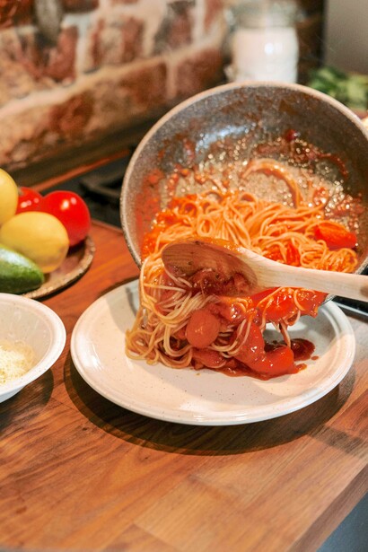 Chef serve macarrão ao molho sugo
