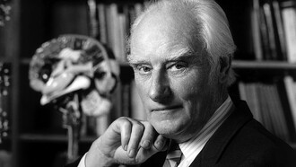 Francis Crick stellte das zentrale Dogma der Molekularbiologie auf: Informationen fließen von der DNA zur RNA und weiter zu den Proteinen, die die Maschinerie des Lebens bilden. Bild: Francis Crick in seinem Büro. Aufnahme um 2004
