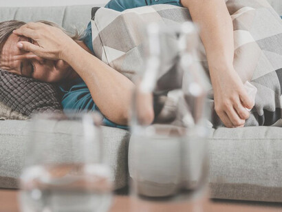 Woman in mourning, expressing sorrow and grief on the couch at home