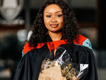 A graduate holds a flower bouquet