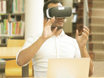 A student immerses himself in a virtual reality experience, exploring complex concepts that mirror the interaction between artificial intelligence and the human brain’s neural networks