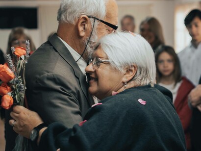 An elderly couple smiling and dancing despite the fact that they are ageing