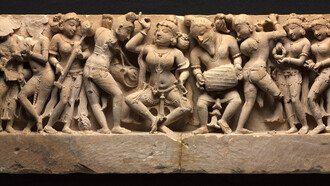 Frieze with Dancer and Musicians, a dancer, who strikes a pose in the center, is accompanied by a full orchestra of musicians in lively variegated poses. At the far left, a woman plays the cymbals, her mouth open in song, Northwestern India, Rajasthan, Sikar, Harshagiri, 10th century