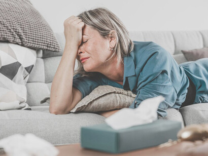 Portrait of a grieving woman in deep sadness and sorrow on the couch at home, mourning a loss