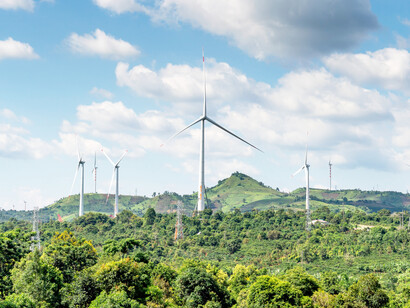 Wind turbines against the blue sky in green fields in Vietnam