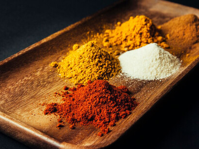 The display features Indian spices arranged on a table, offering a visual guide to essential ingredients for authentic Indian food preparation