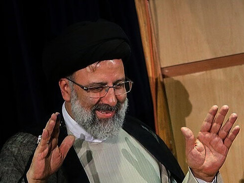 Raisi greeting an unseen crowd with both hands