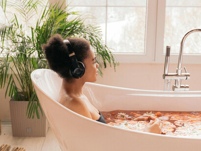A woman in a bathtub with headphones on