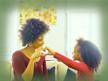 A mother and daughter put their hands together to form a heart for love