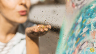 Donna che soffia su brillantini dorati: "Bisogna iniziare a dare valore al proprio tempo e a quello di chi abbiamo intorno. Abbiamo bisogno di sostituire la quantità con la qualità: spesso meno, significa di più"