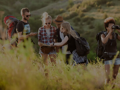 Young friends with backpacks enjoying view, traveling in canyon