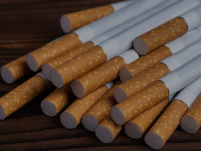 On a wooden background, a heap of cigarettes