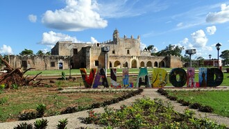 A colorful sign stands prominently in front of the historic Convento de San Bernardino de Siena, showcasing the picturesque town that captivates visitors with its riotously colorful streets and rich history