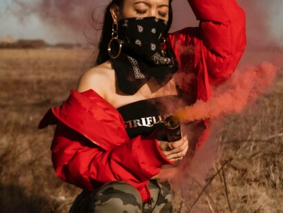 A woman with a bright red canister is casually wearing her red jacket and black girl-influence top for the opportunity to be seen on social media