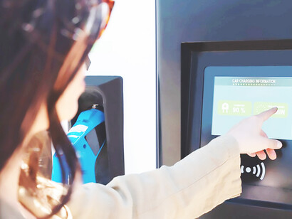 The eco-conscious moment as a woman, seen from the side, makes a sustainable choice while selecting a charging option, emphasizing environmentally friendly practices and technology adoption