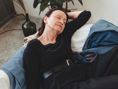 A woman napping on her chair and is grieving silently over the clothes of the love she lost
