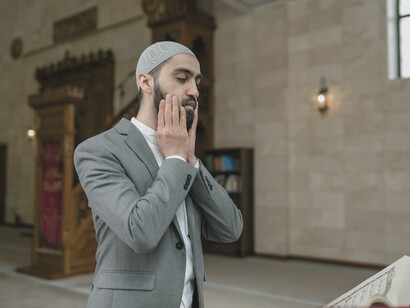 Man wearing gray suit praying