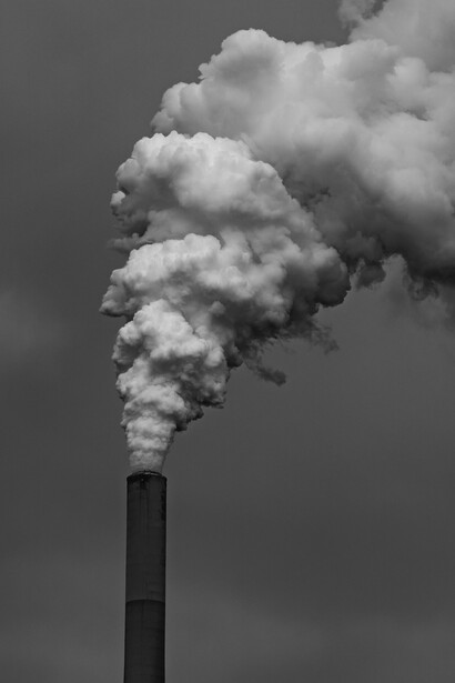 Black and white image of smoke coming out from a power plant