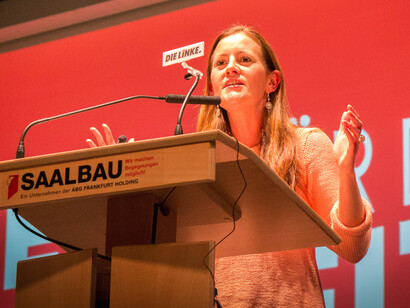 As the room fills with attentive listeners, the speaker highlights the importance of addressing economic inequalities and the voices of the working class in today’s political landscape