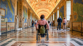 A wheelchair user explores the Vatican Museums, highlighting the importance of accessibility at one of the world's most visited cultural landmarks